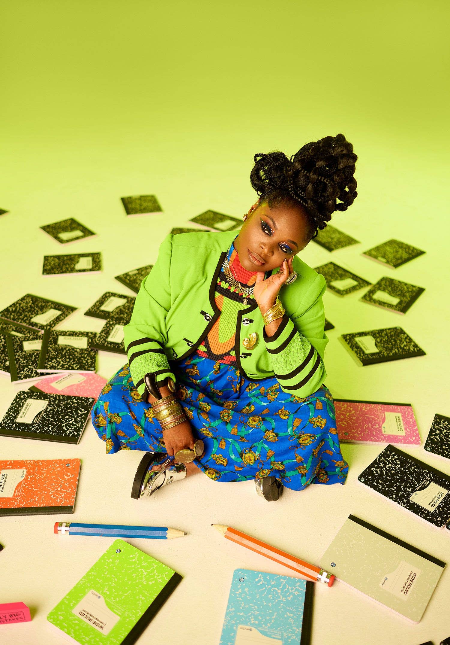 Tank Ball sitting with notebooks on a green background