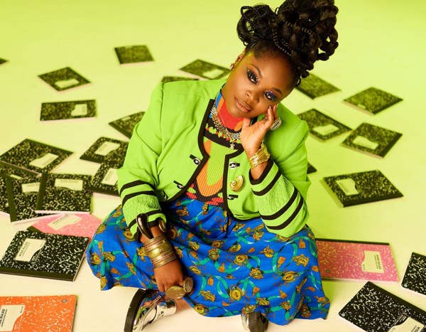 Tank Ball sitting with notebooks on a green background