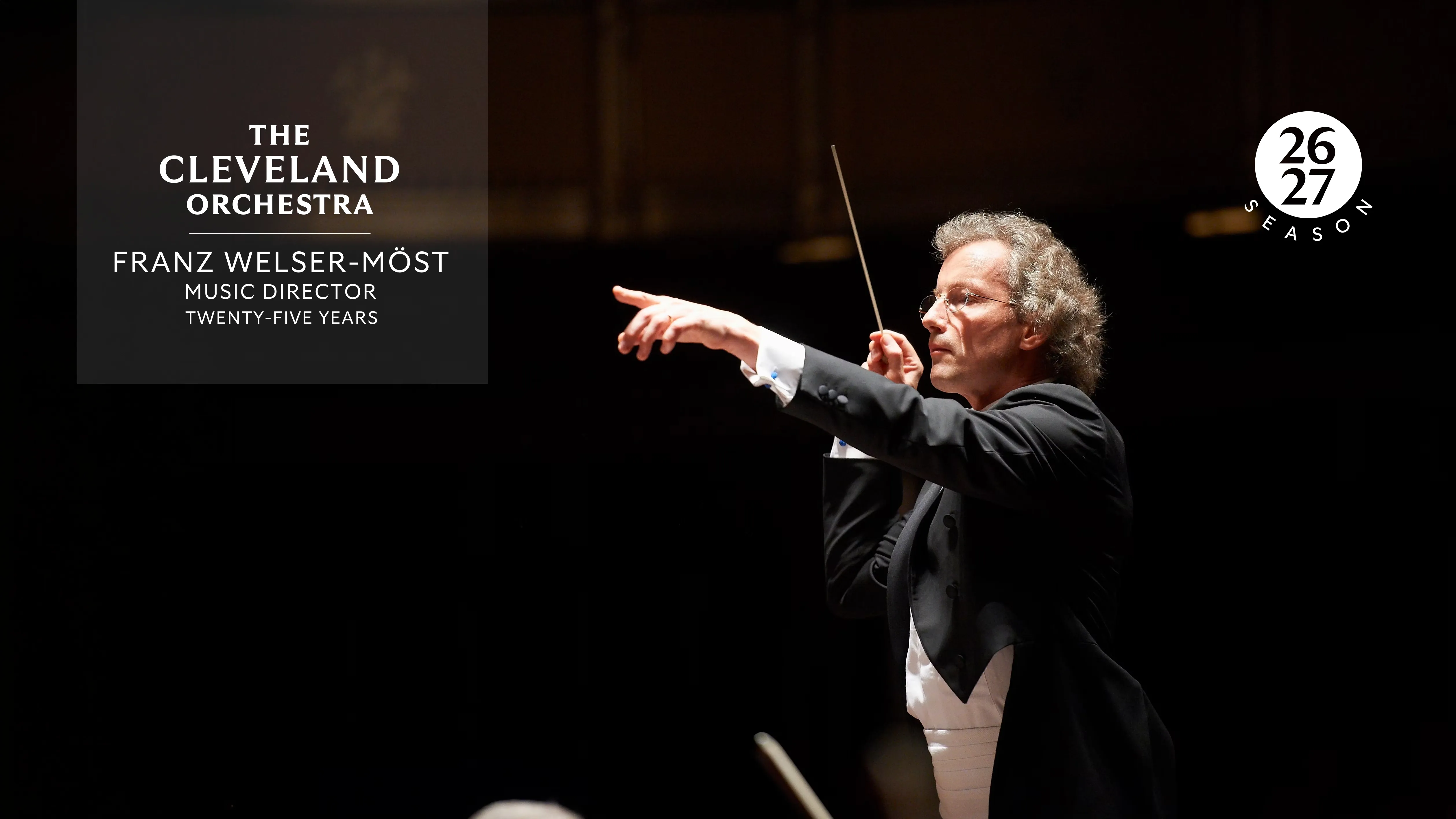Franz Welser-Möst conducting The Cleveland Orchestra, arms raised with a baton on a dark stage backdrop. Logos 