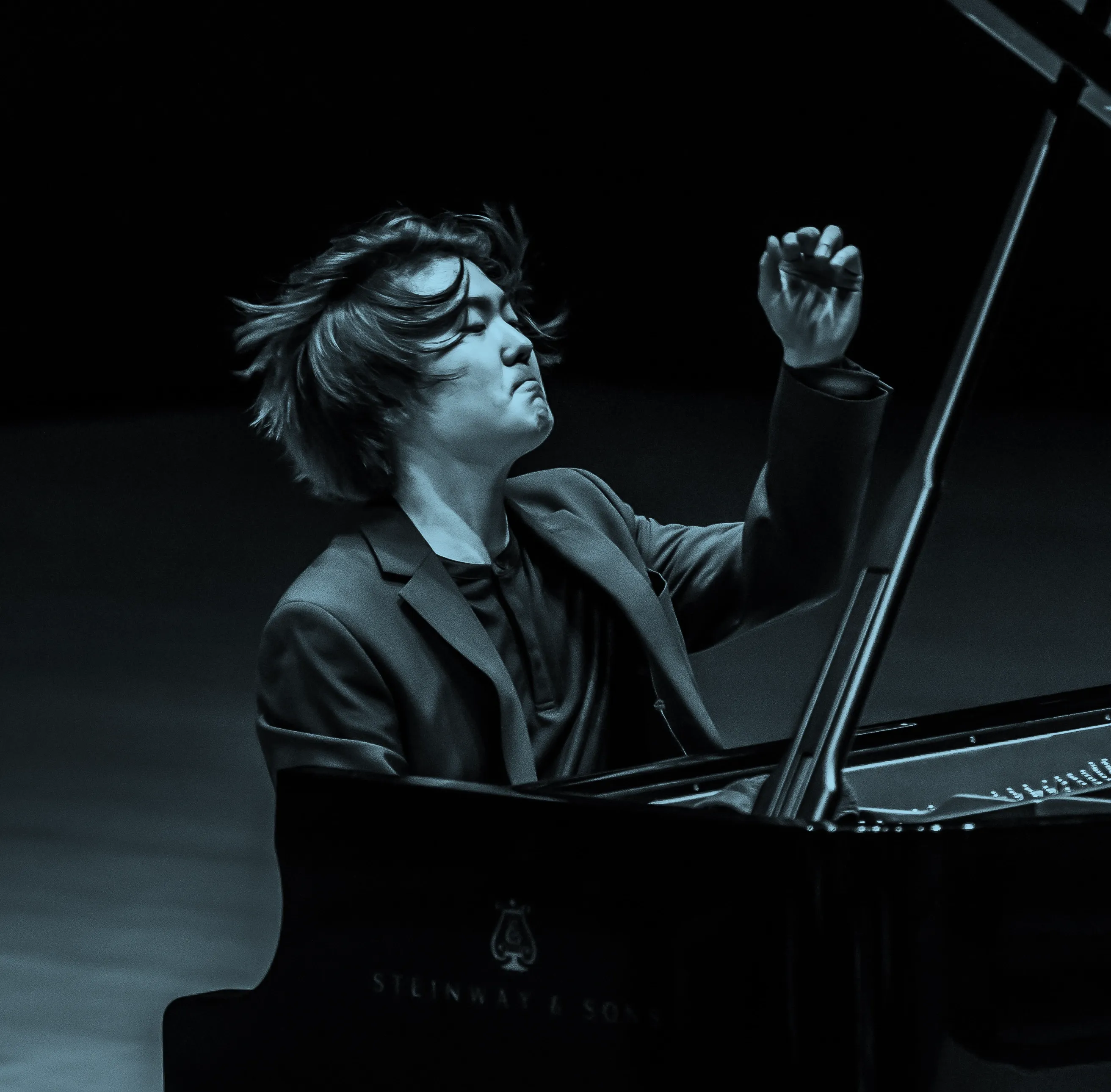 Pianist, Seong-Jin Cho, passionately performing on a Steinway & Sons grand piano, with expressive hand gestures and focused expression.