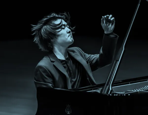 Pianist, Seong-Jin Cho, passionately performing on a Steinway & Sons grand piano, with expressive hand gestures and focused expression.