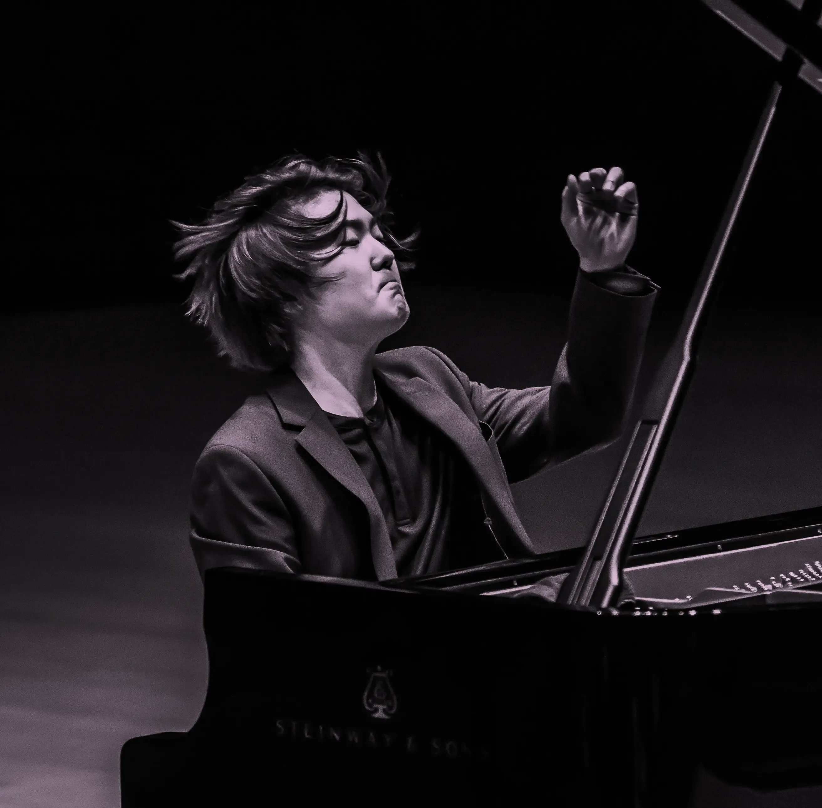 Pianist, Seong-Jin Cho, passionately performing on a Steinway & Sons grand piano, with expressive hand gestures and focused expression.