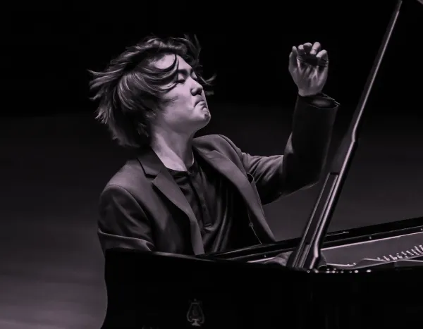 Pianist, Seong-Jin Cho, passionately performing on a Steinway & Sons grand piano, with expressive hand gestures and focused expression.