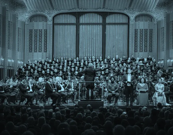 The Cleveland Orchestra and TCO Chorus performing on stage with Franz Welser-Möst leading, surrounded by an ornate interior of MAndelo Concert Hall.