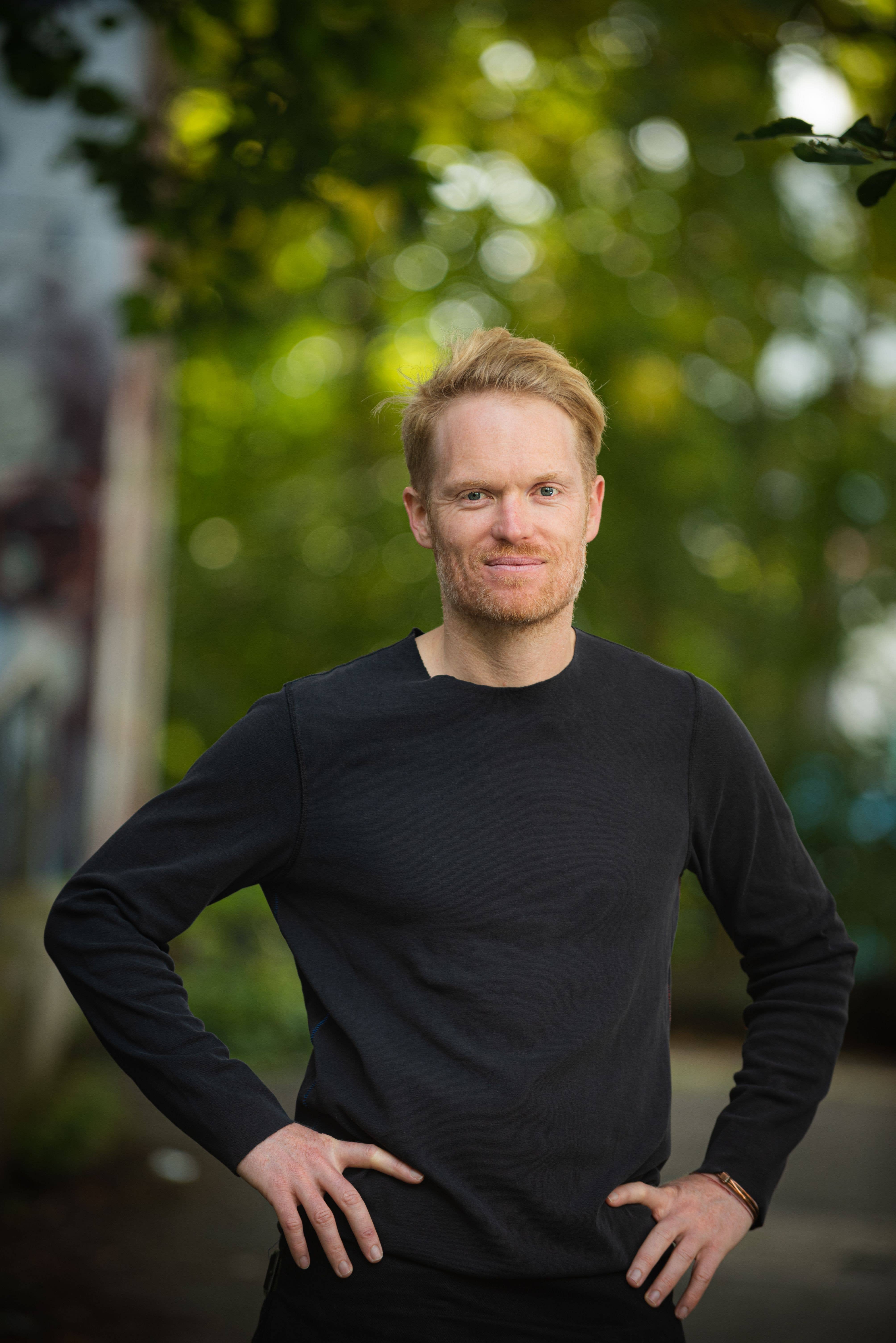 Frederic Wake-Walker standing in front of a forested background