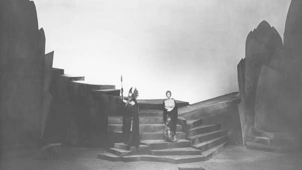 two actors pose on steps between fake rocks