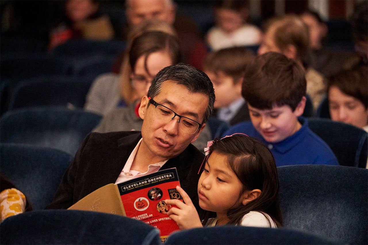 Father and daughter reading program book in Mandel