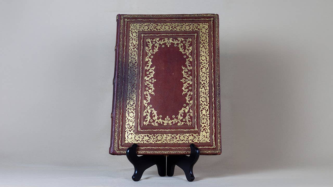a brown leather book embossed with gold