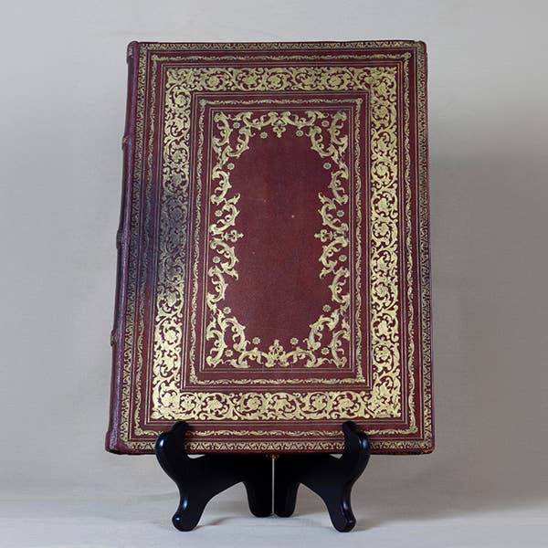 a brown leather book embossed with gold