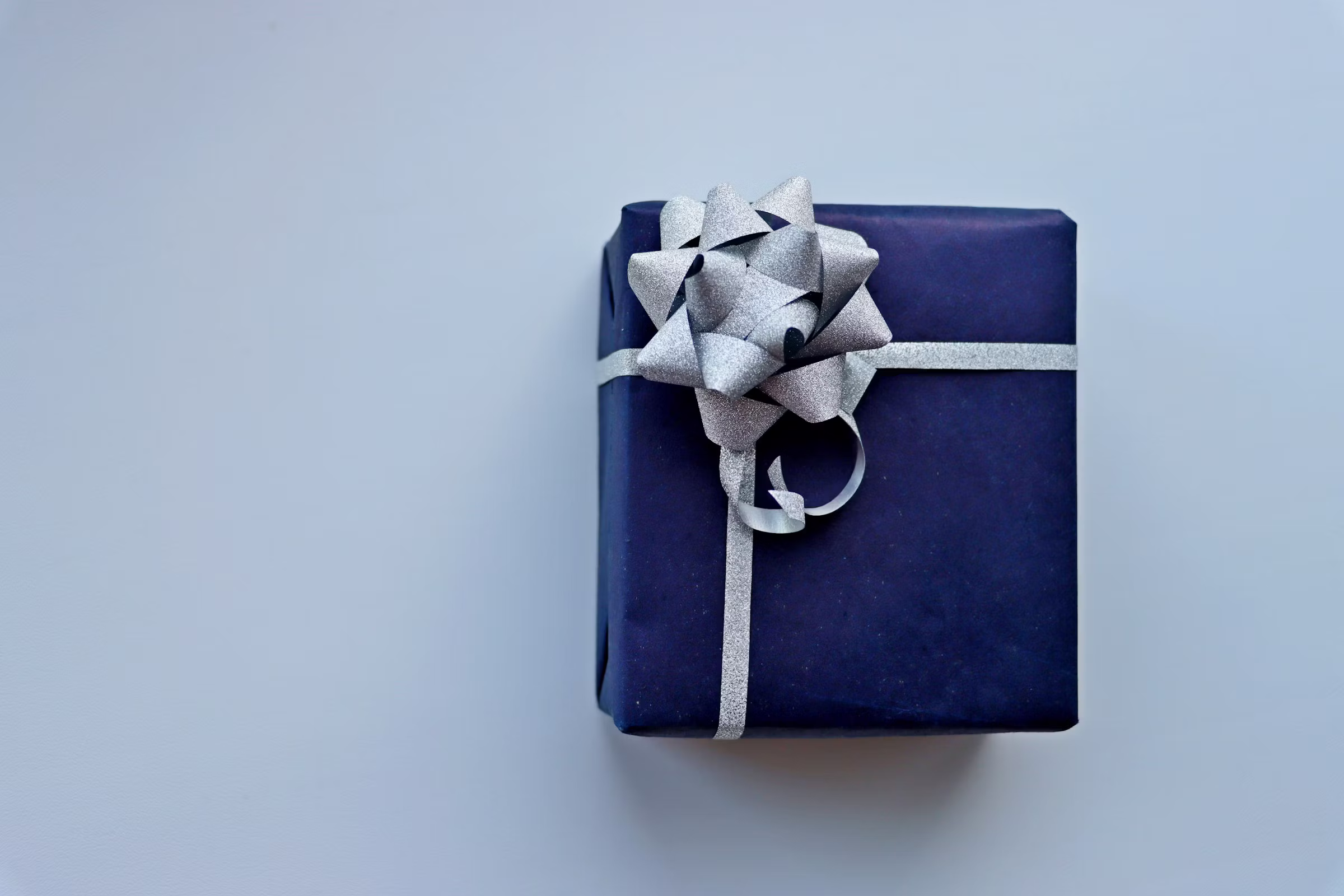 blue gift box with silver bow on a white background