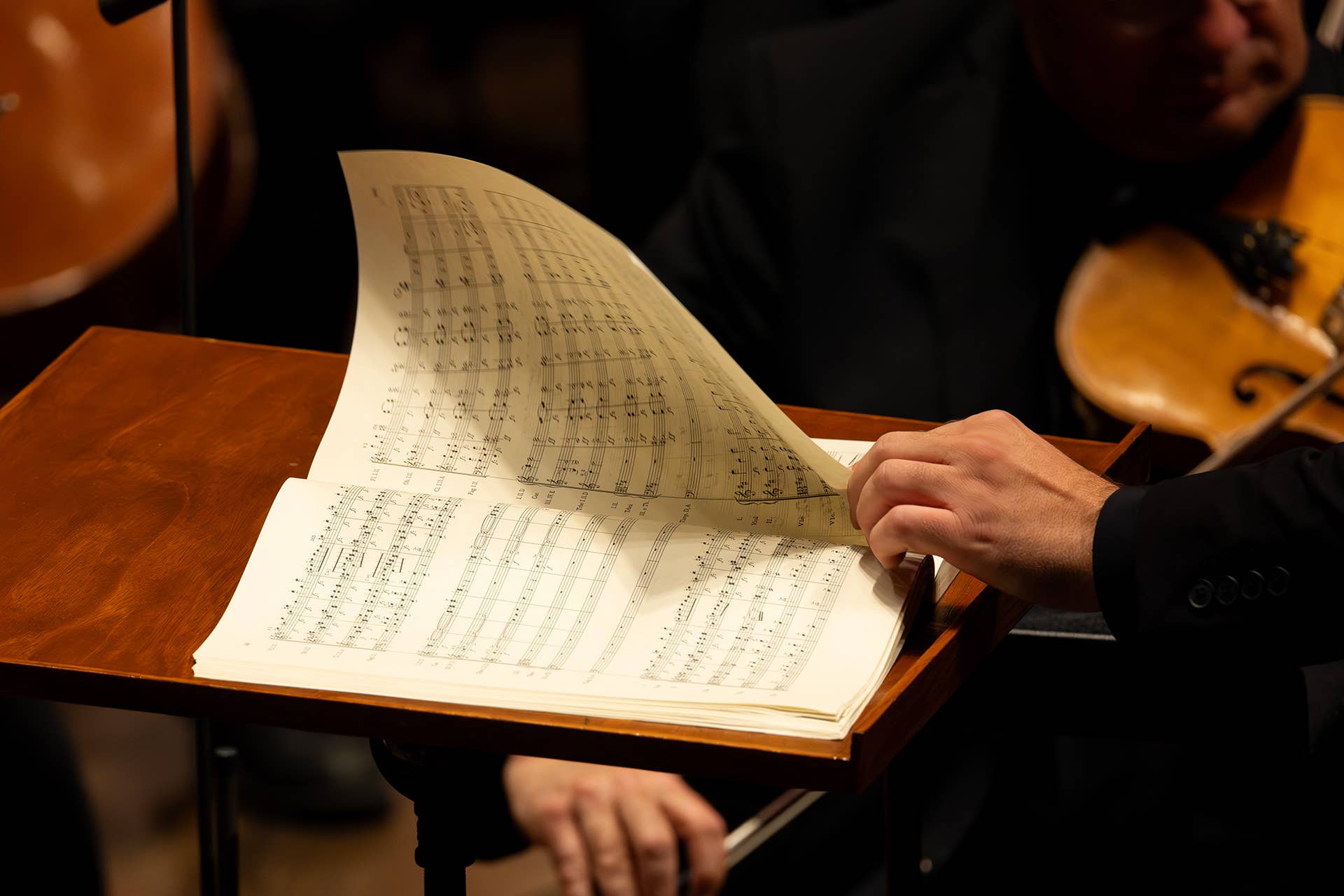 hand flipping through sheet music during a concert