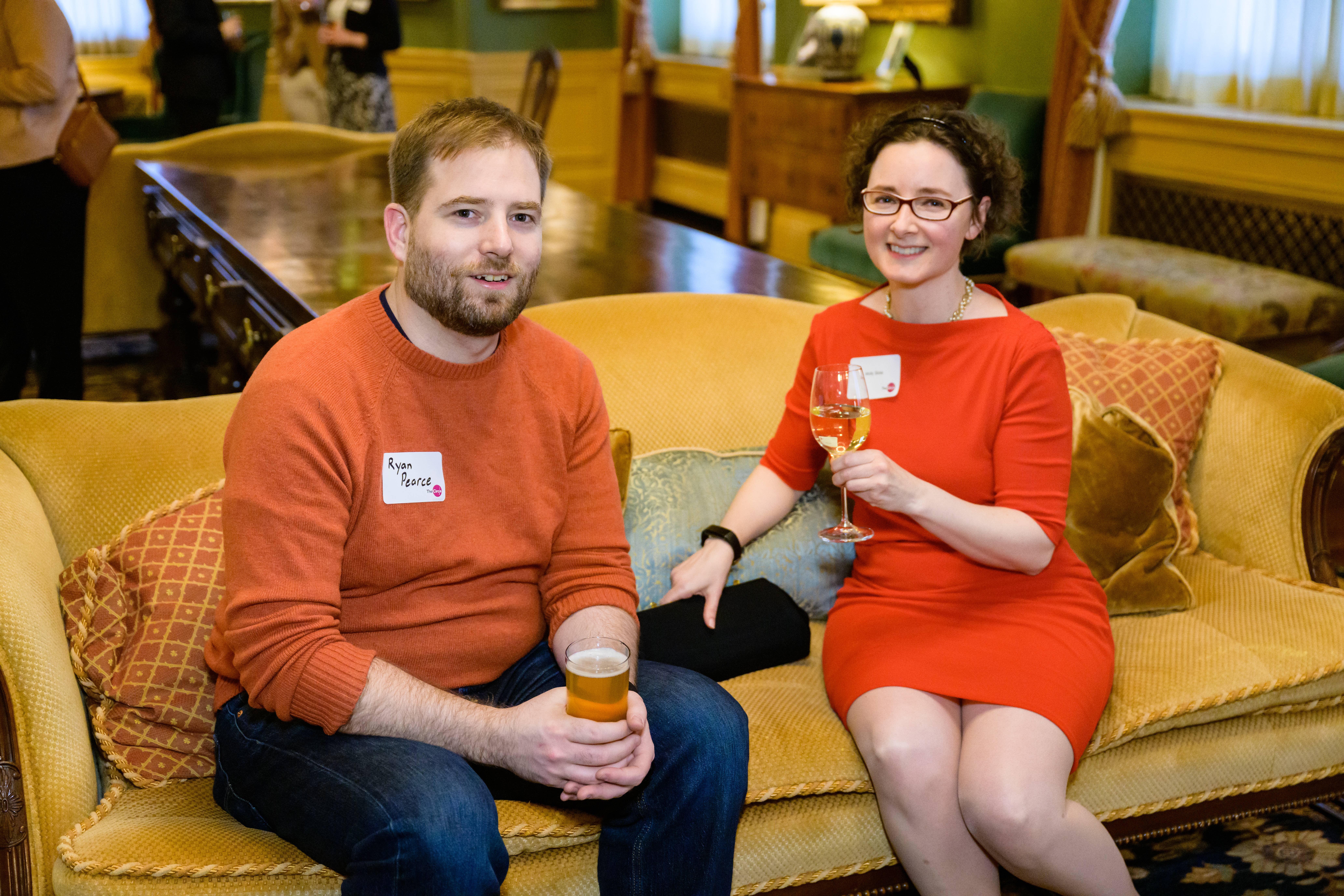 a man and woman sitting on a sofa in the Ginn Suite