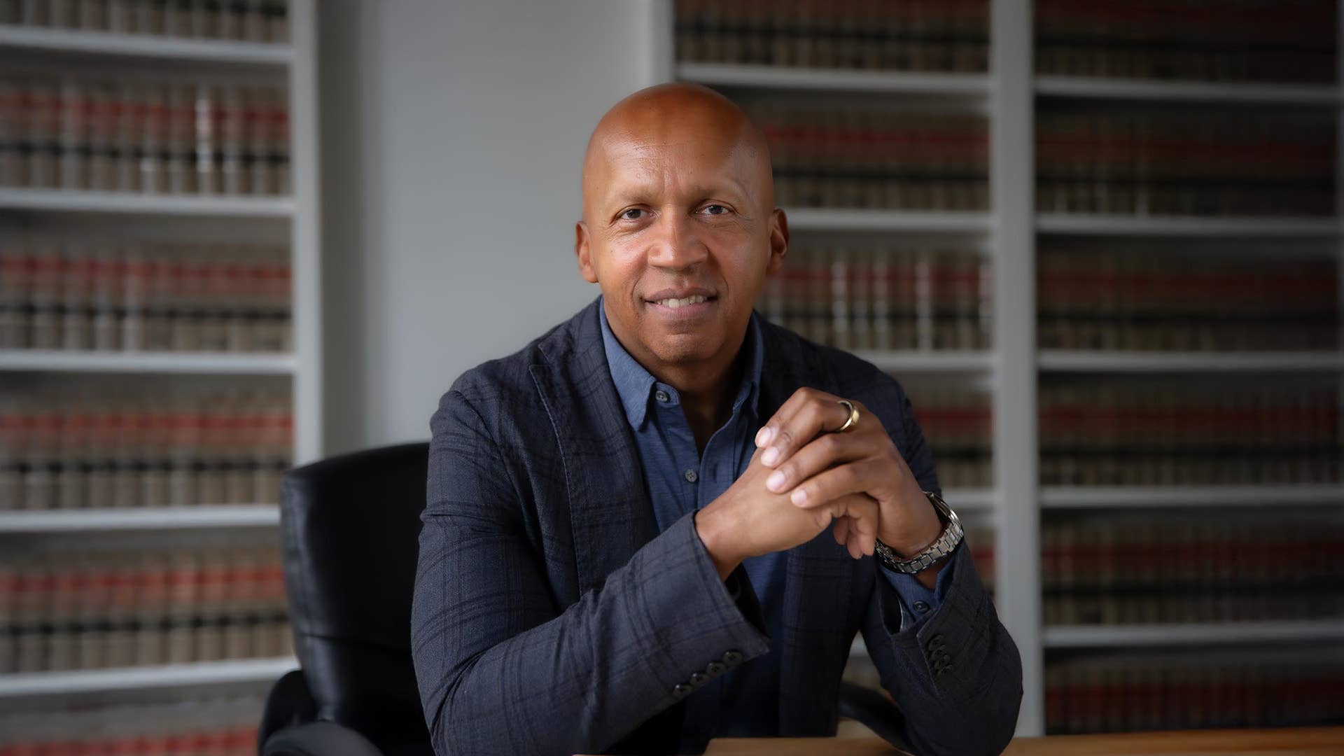 Bryan Stevenson in front of bookshelves