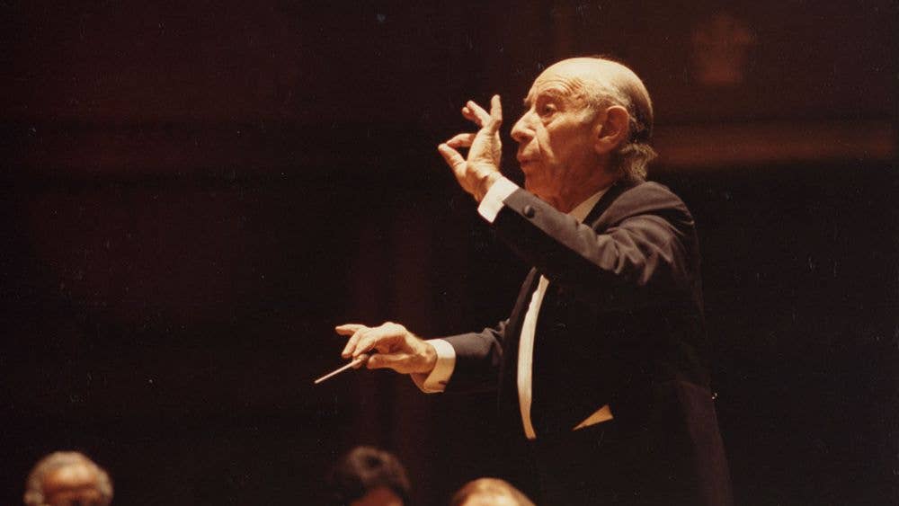 Leinsdorf guest conducting the Orchestra. He is making a gesture with his left thumb and forefinger to emphasize the tapering of a musical phrase.