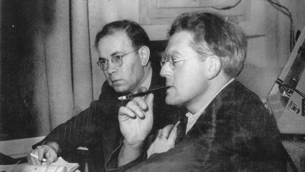 Rodzinski is seated and holding a cigarette holder in his mouth while he contemplates the playback of a prospective recording by The Cleveland Orchestra. A small score is open in front of him.