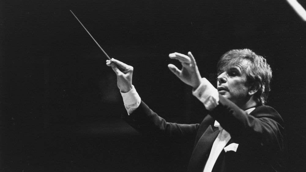 Photograph focused closely on Christoph von Dohnányi. He is conducting, and is in the middle of a cue.