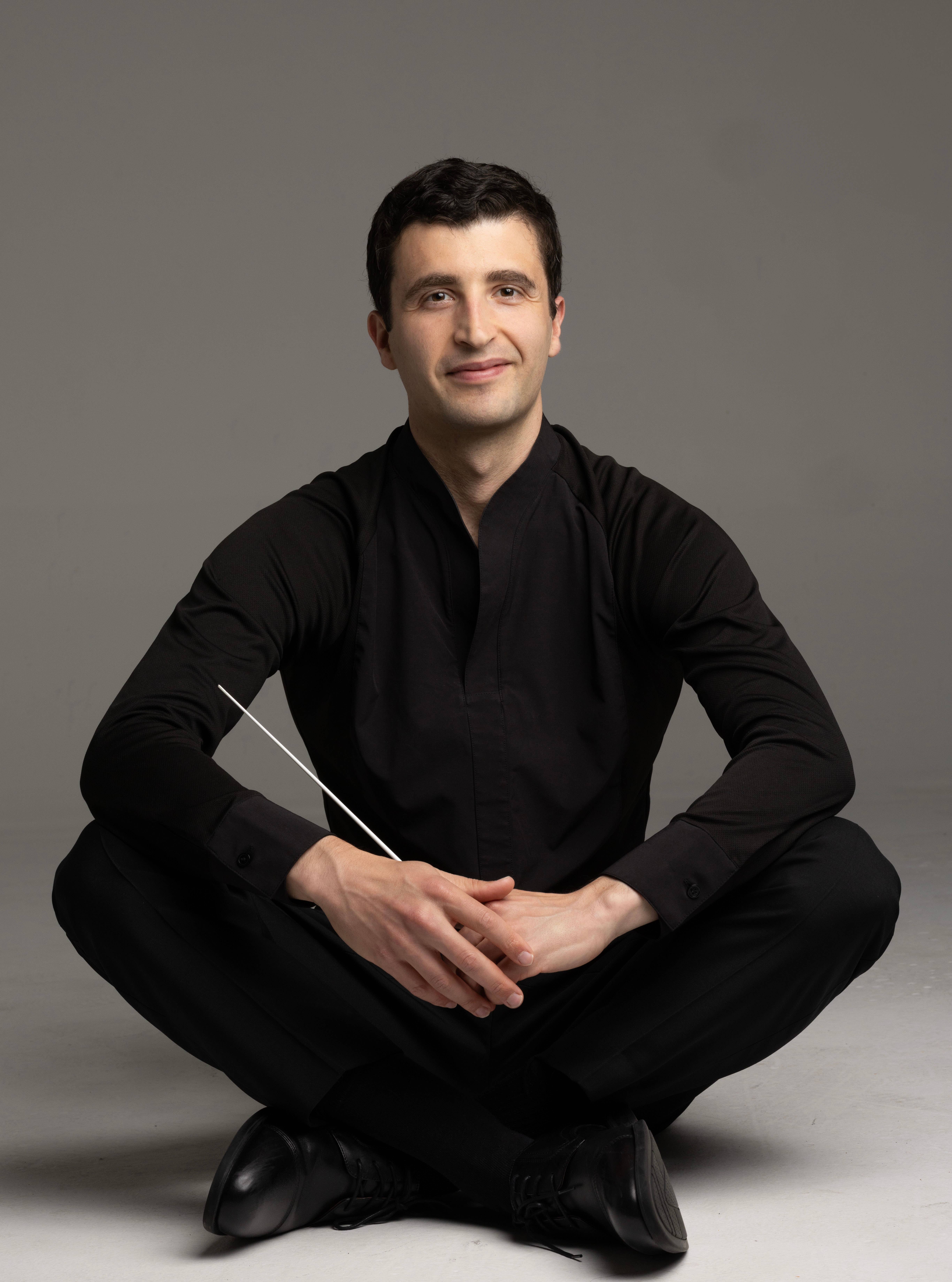 Jacob Joyce, conductor, featured seated
