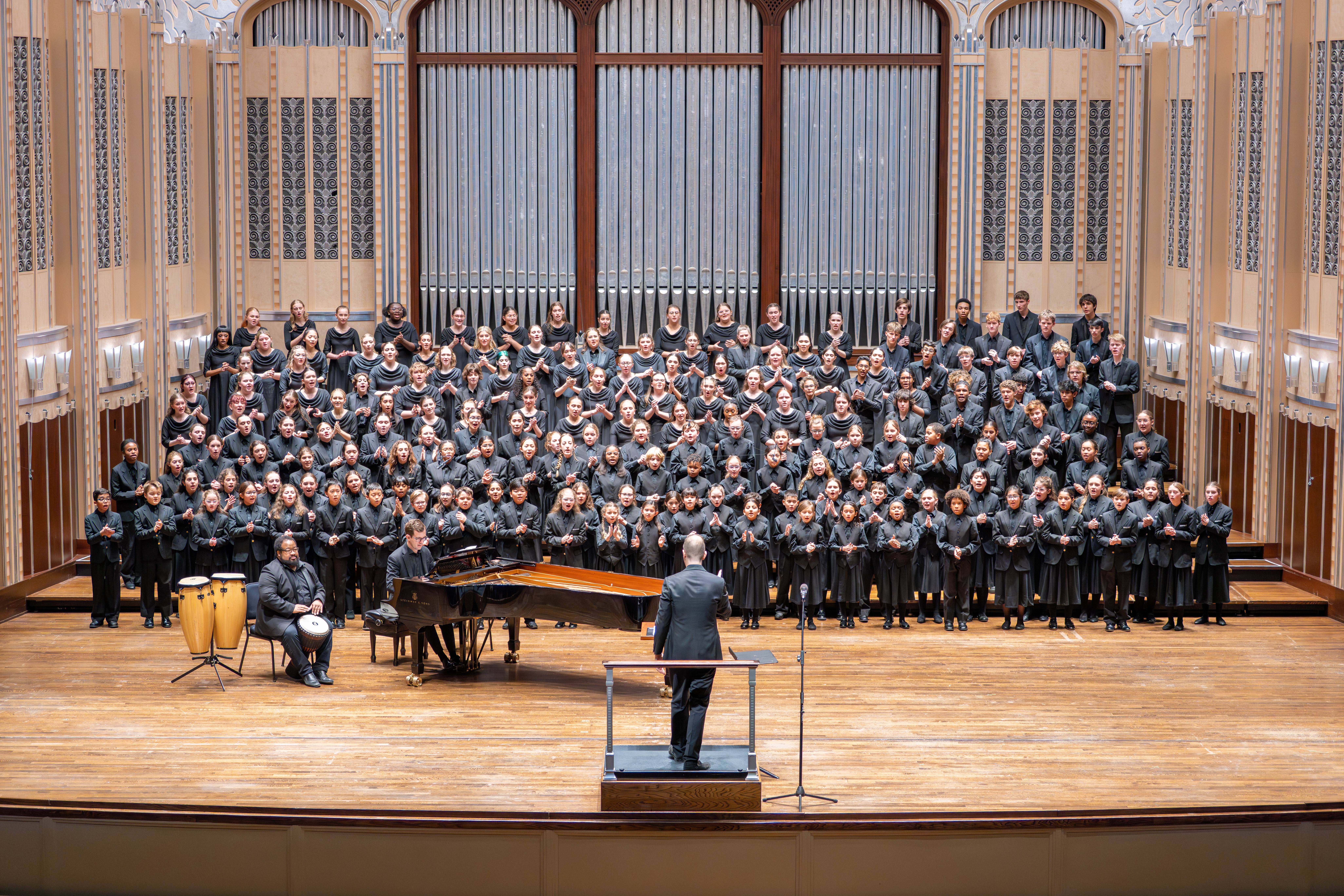 TCO Youth Choirs on Mandel stage, singing. 