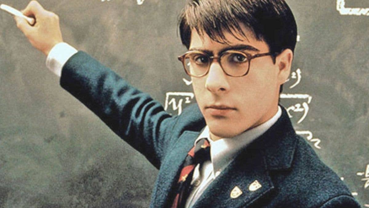 Max Fischer standing at a chalk board with equations behind him.
