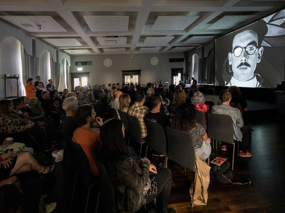 Audience watching surrealist short film Time Flower during Flatpack Festival.