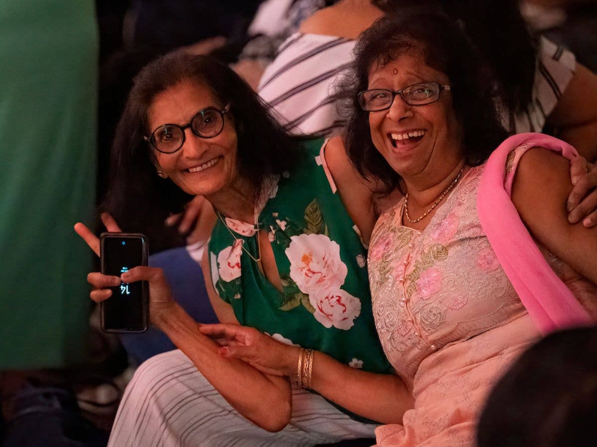 Two women wearing glasses smile and pose for the camera at the Waldorf Revival.