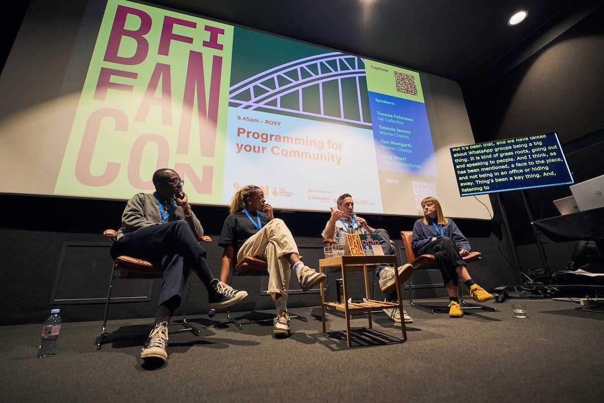 Panel discussion with “BFI FAN CON” slides on screen and speakers seated on stage with microphones.