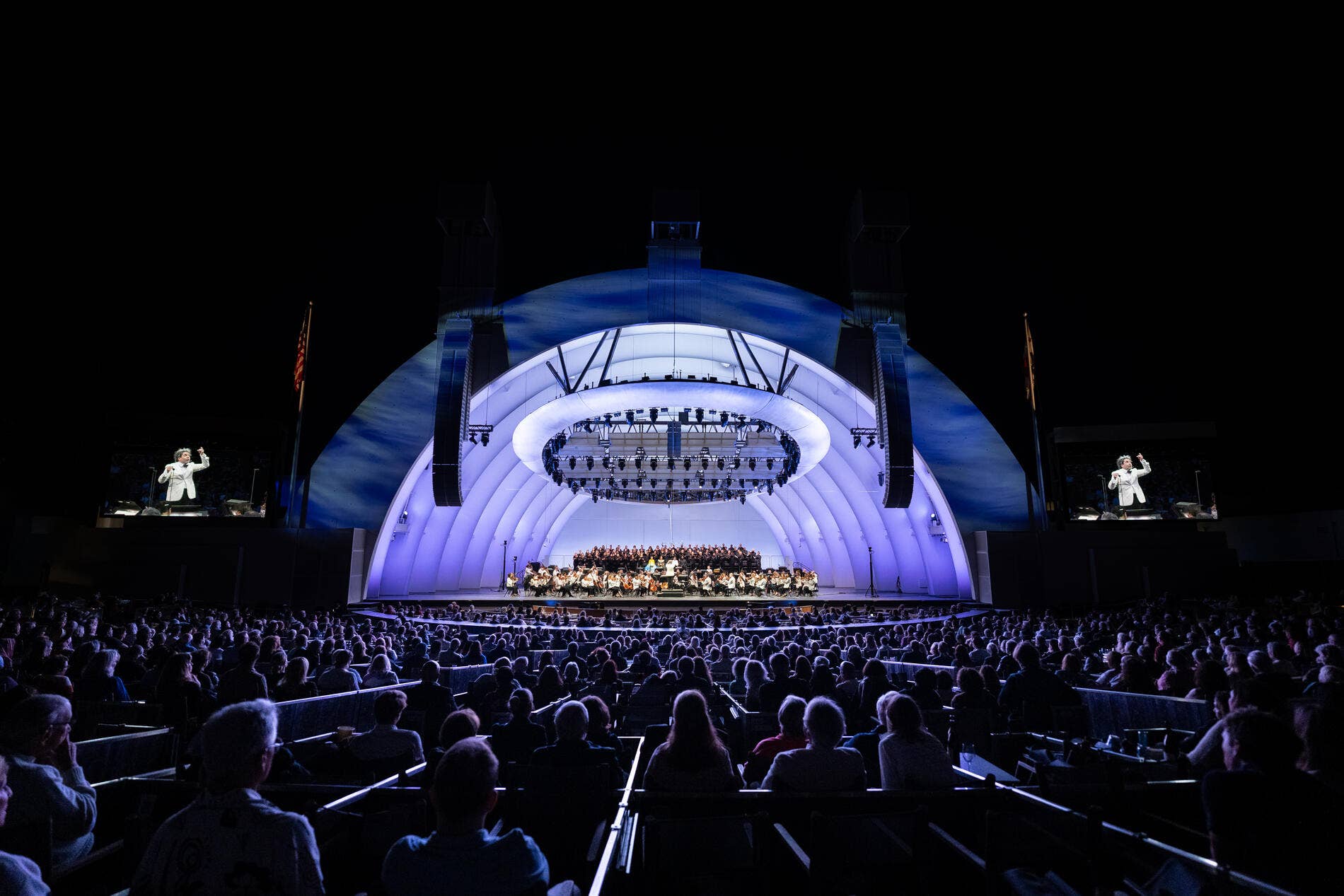 Gustavo Dudamel is on stage with the LA Phil. The Bowl shell is lit up in a soft purple light. It's a perfect summer night at the Bowl!