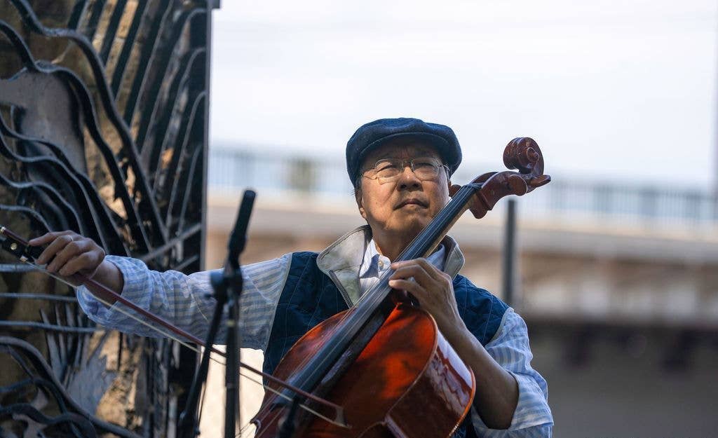 Yo-Yo Ma playing cello by the Los Angeles River gates.