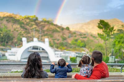 Family watching a rainbow over a hillside with the Bowl shell in the background