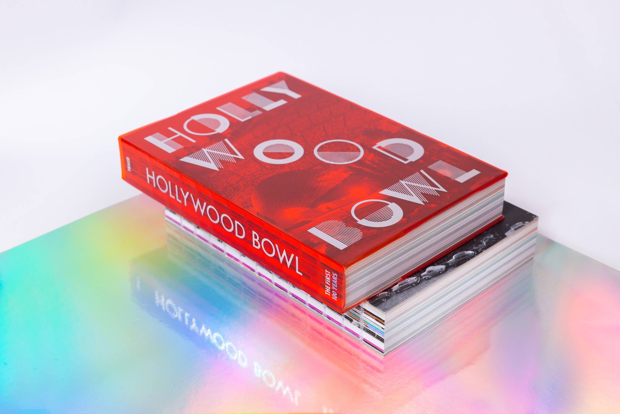 Red book stack titled HollyWood Bowl with stylized letters on glossy covers, on pastel colored surface