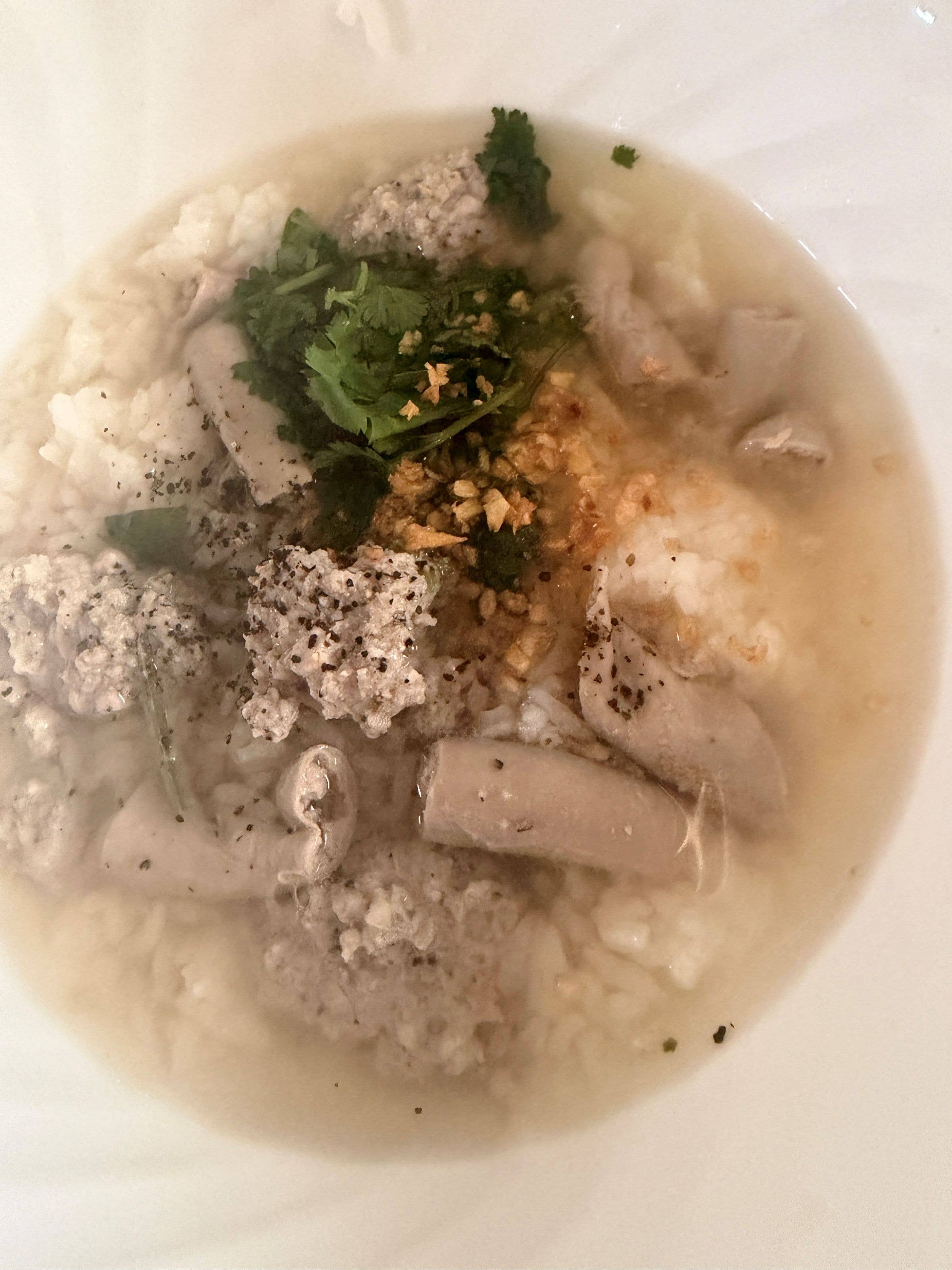Bowl with chopped parsley, minced meat, and cracked pepper scattered on the surface