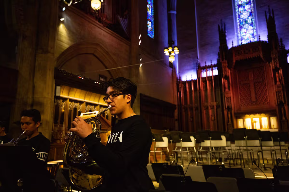 Andy Gonzalez, a YOLA alumni, plays the horn inside a cathedral.