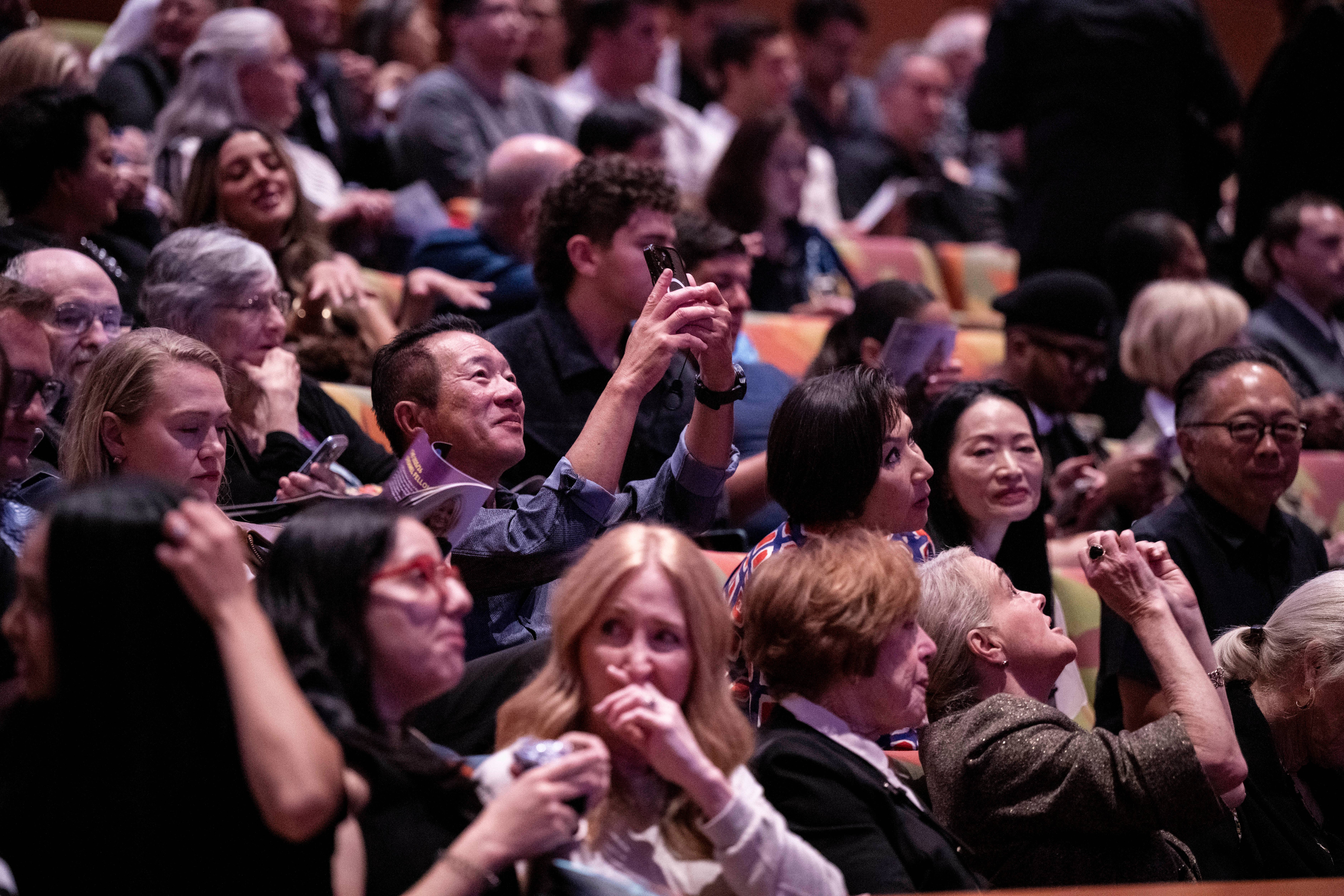 Crowd at a la phil event, cheering fans with one man raising a finger in the foreground.