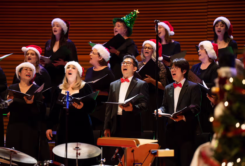 choir on stage performing in festive holiday hats