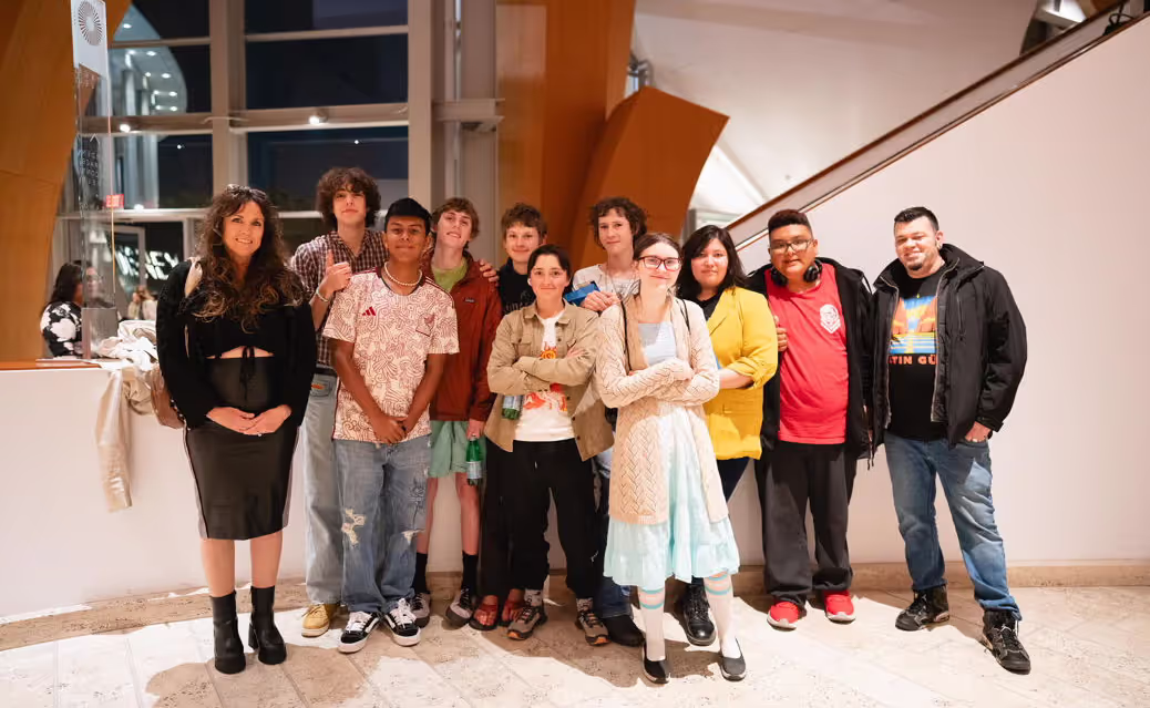 crowd of younger folks posing at the concert hall