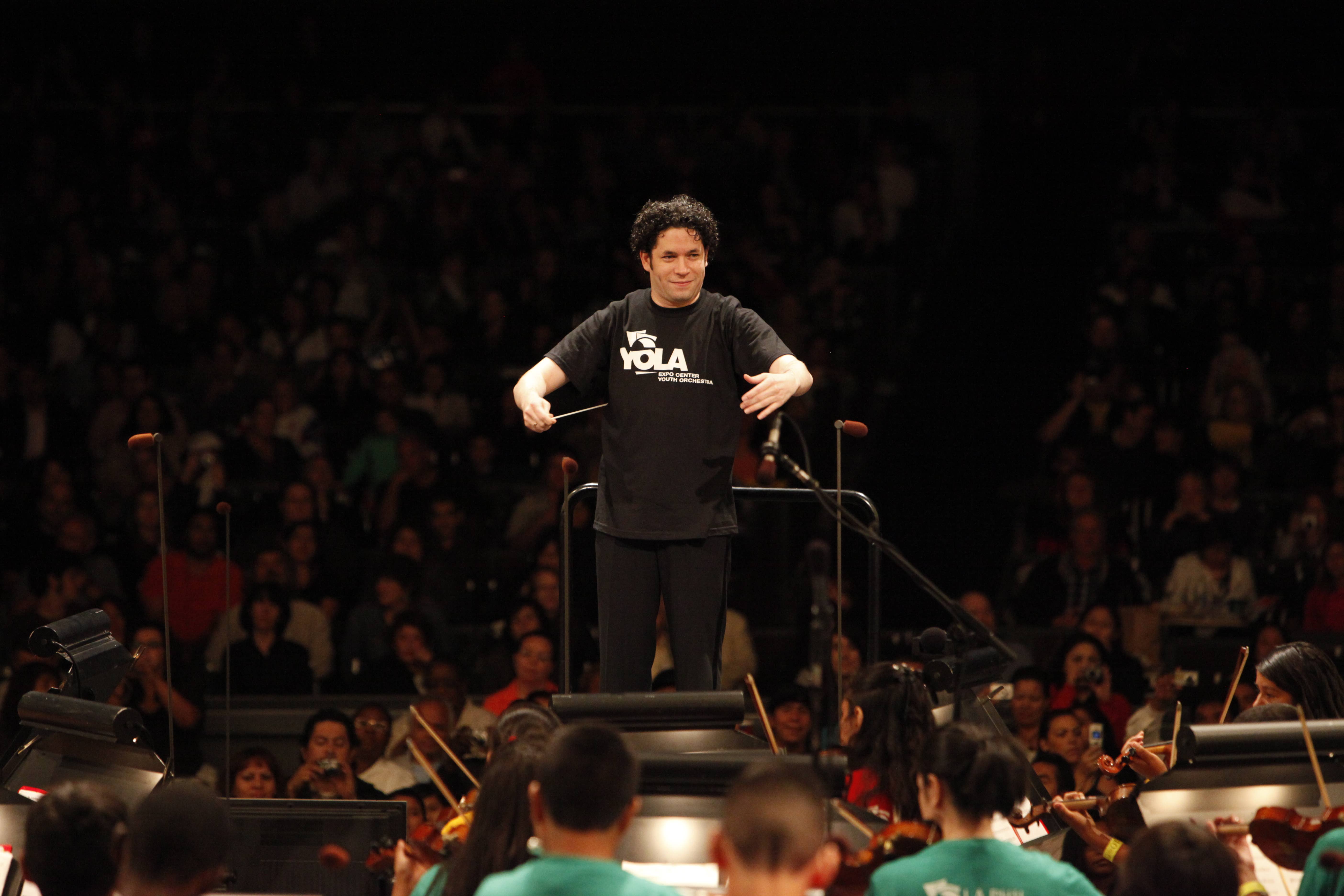 Gustavo Dudamel stands at the front of the YOLA orchestra while conducting during a premiere performance in 2009.
