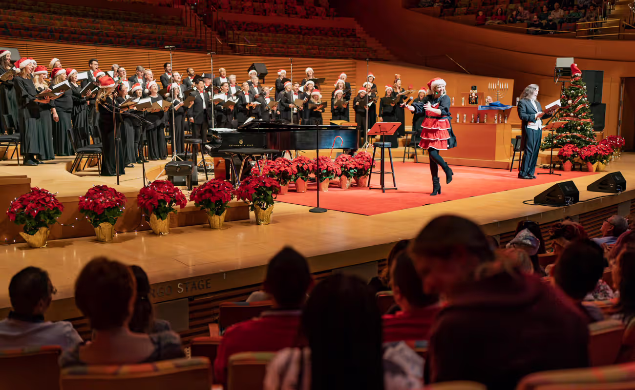orchestra performing on stage with festive holiday decor