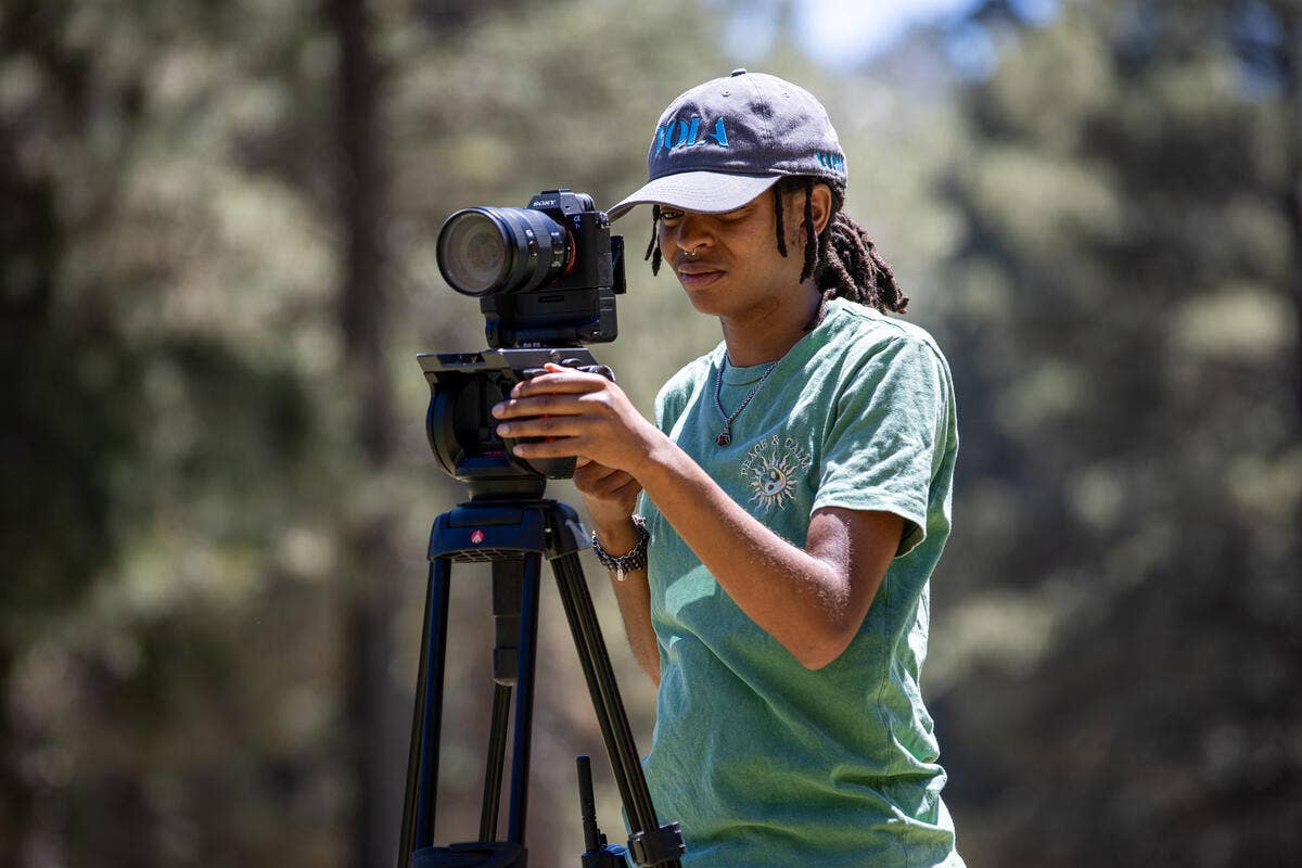 IATSE Workforce Development student records clips outdoors at YOLA Camp.