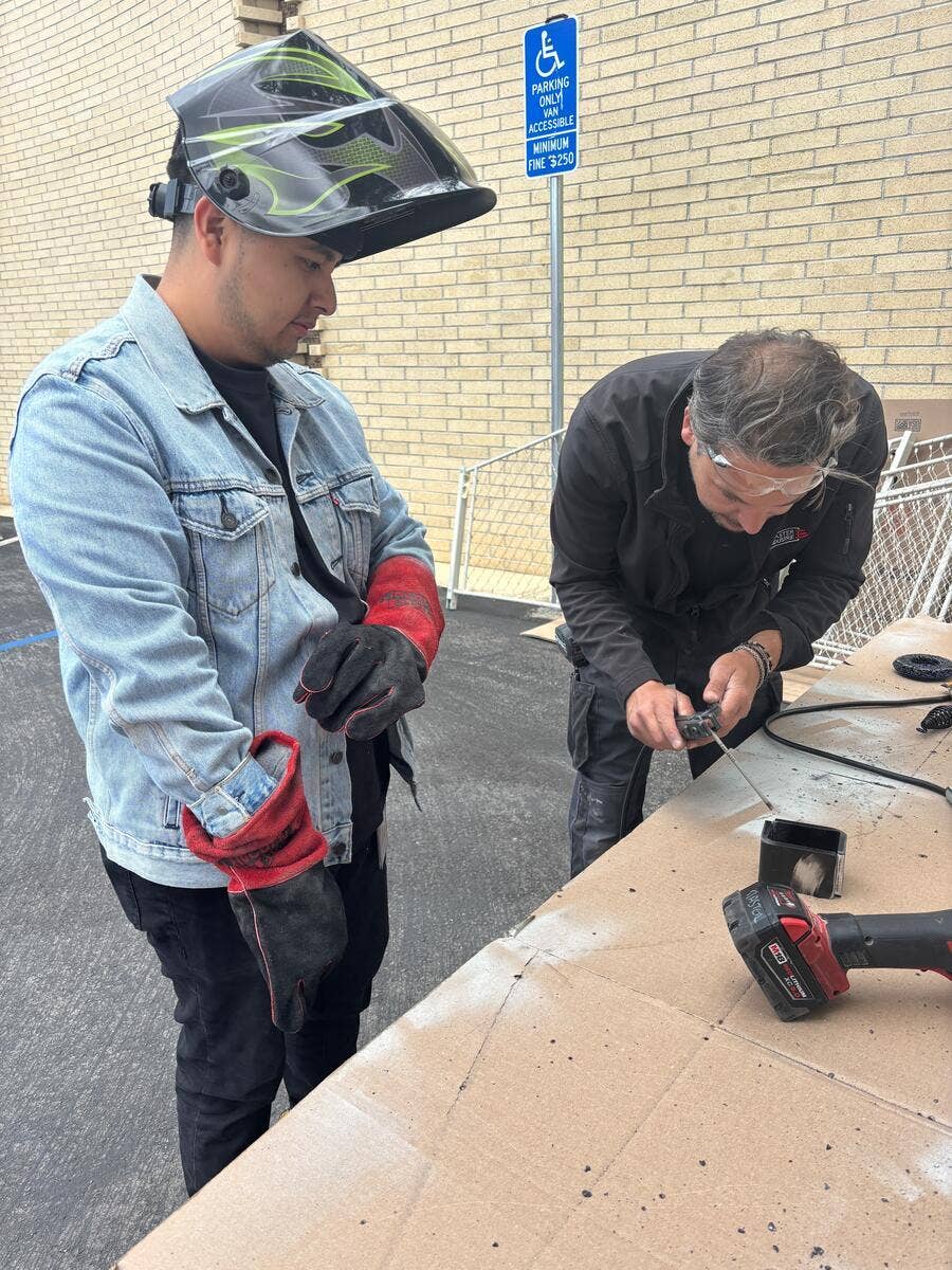 IATSE Workforce Development student learns how to solder outdoors. 