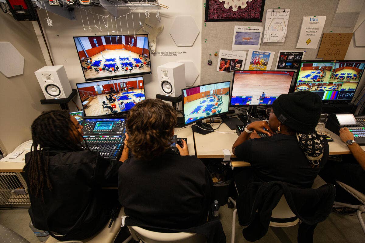 IATSE Workforce Development students assess several monitors while learning stagecraft.
