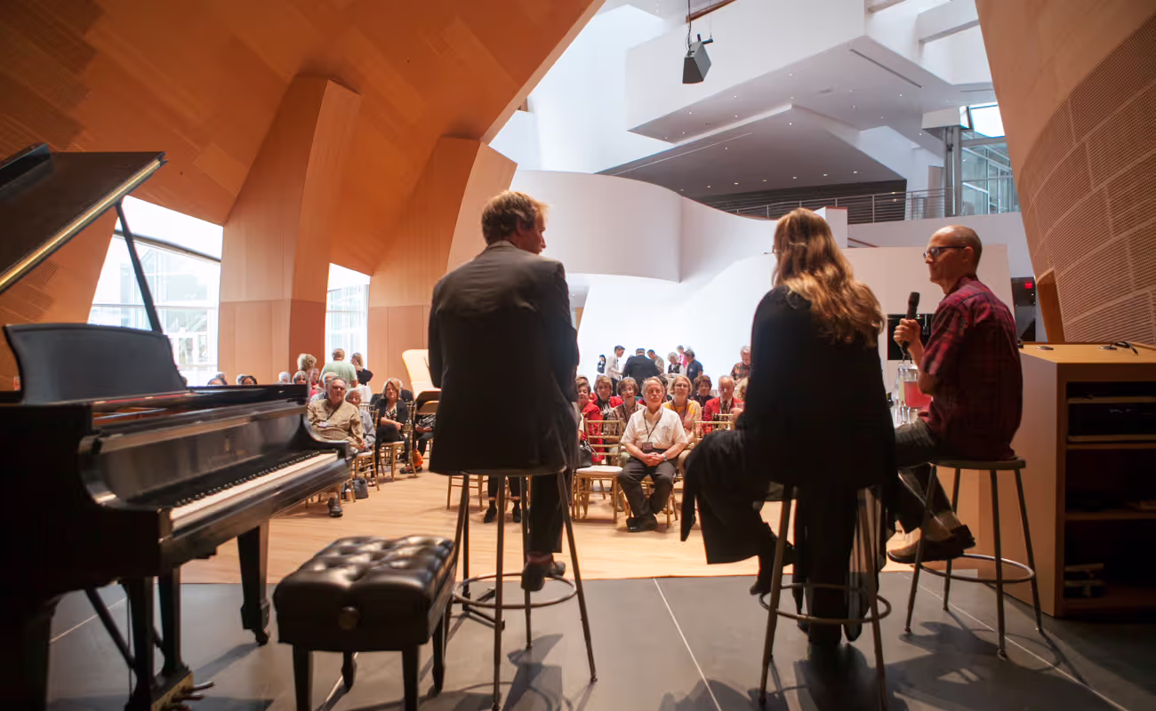behind performers giving a talk on stage with audience
