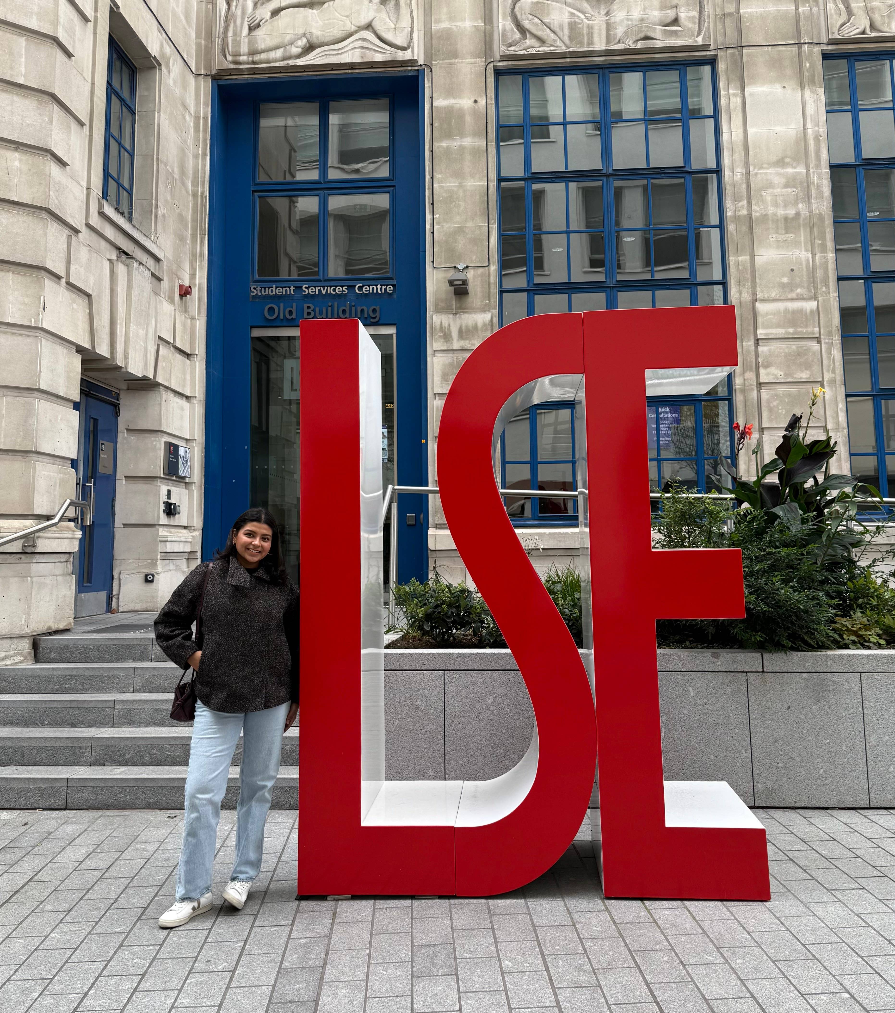 Mailene Polanco poses next to a large LSE sculpture outdoors.