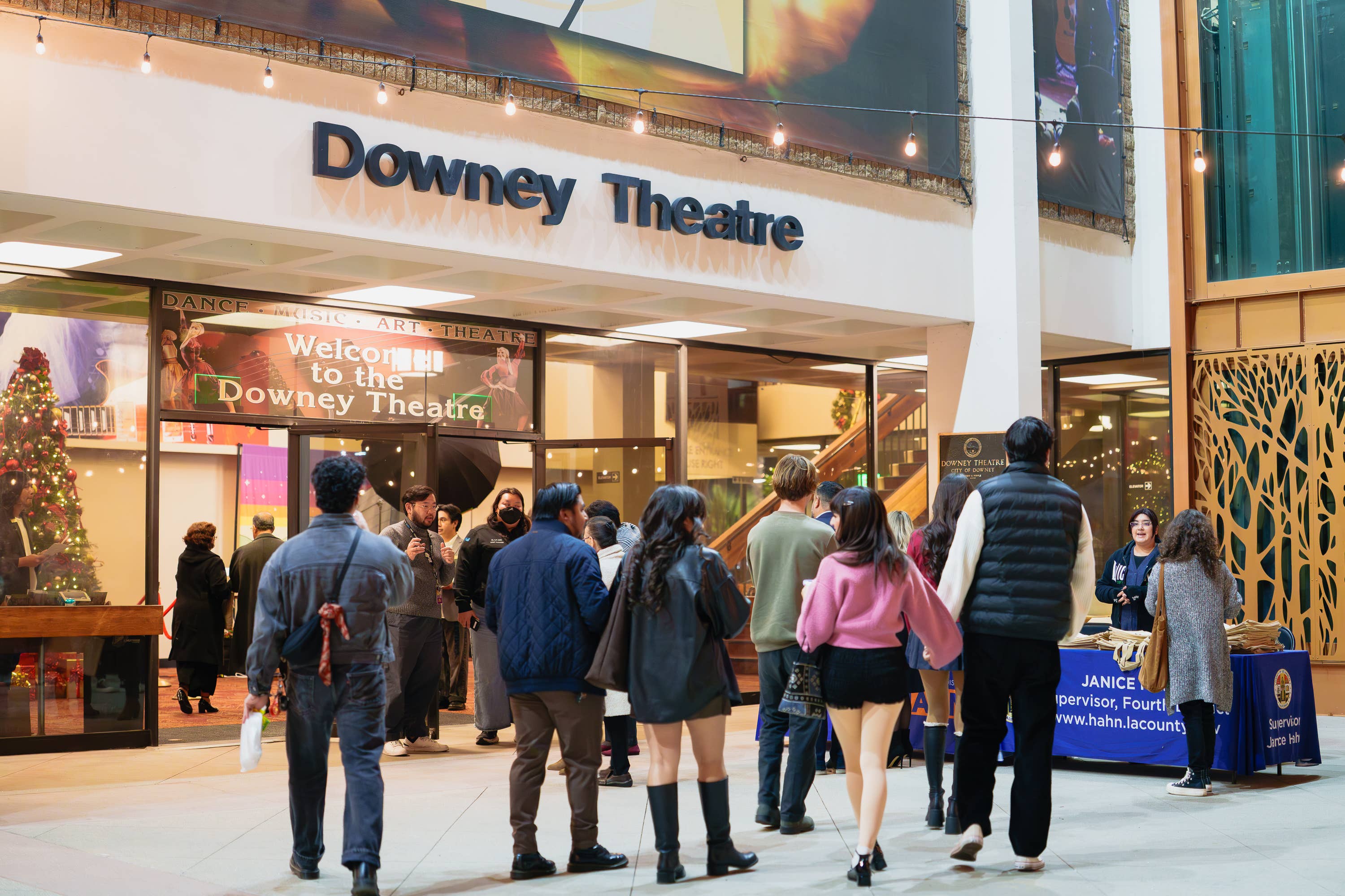 Crowd gathered at the Downey Theatre entrance under marquee lights, with Downey Theatre sign and banners.