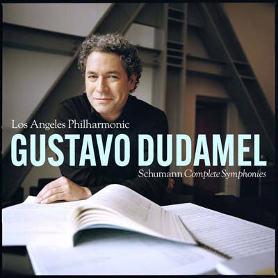 Gustavo Dudamel portrait seated at a table with open sheet music, with Los Angeles Philharmonic Schumann Complete Symphonies text