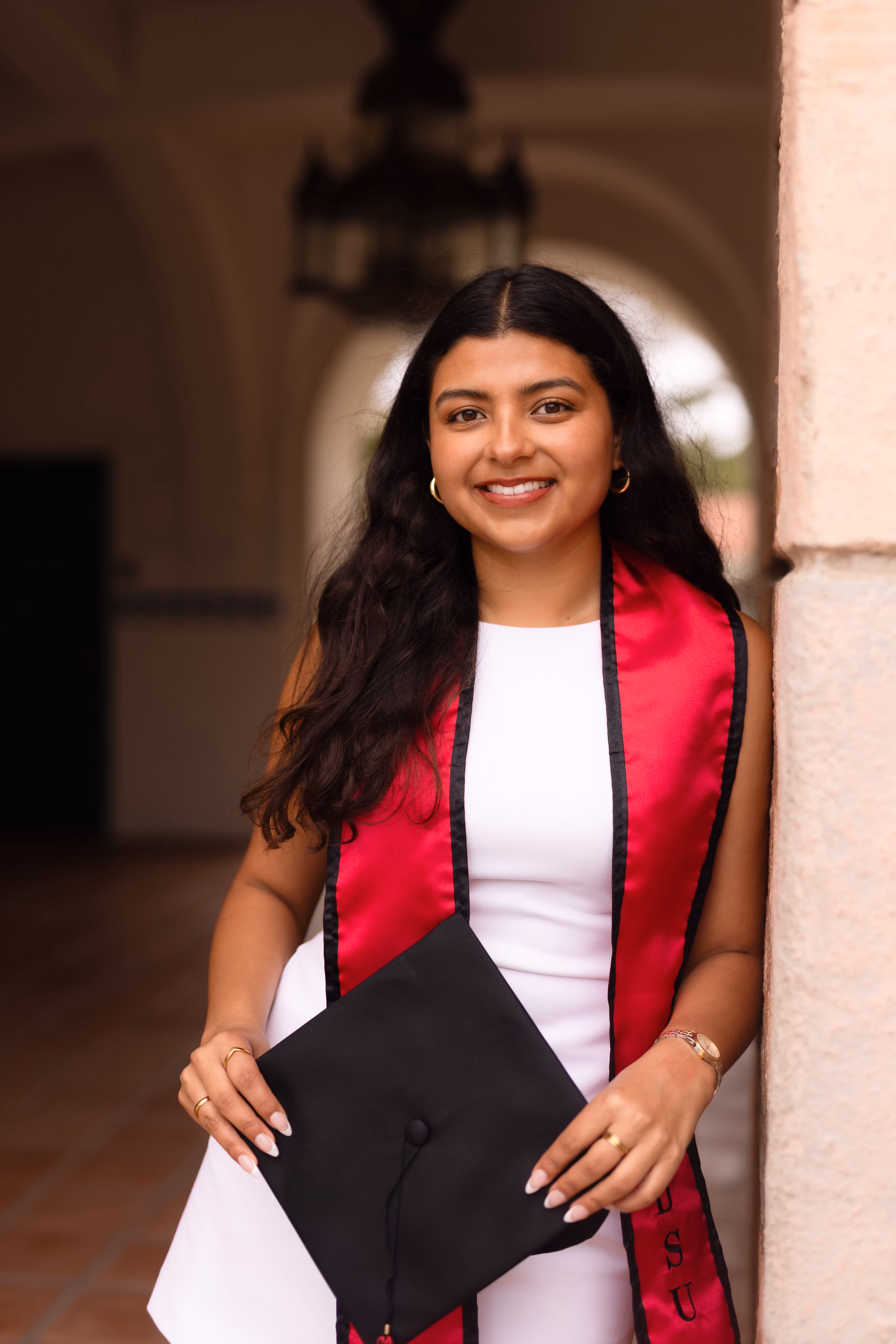 Mailene Polanco posa con un birrete y una banda de graduación. 
