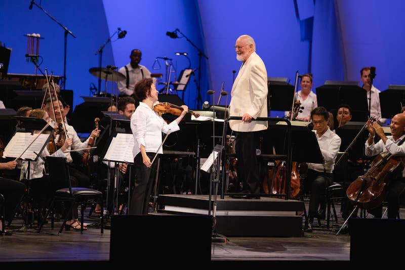 Bing Wang and John Williams look at each other on stage during a performance at the Hollywood Bowl.
