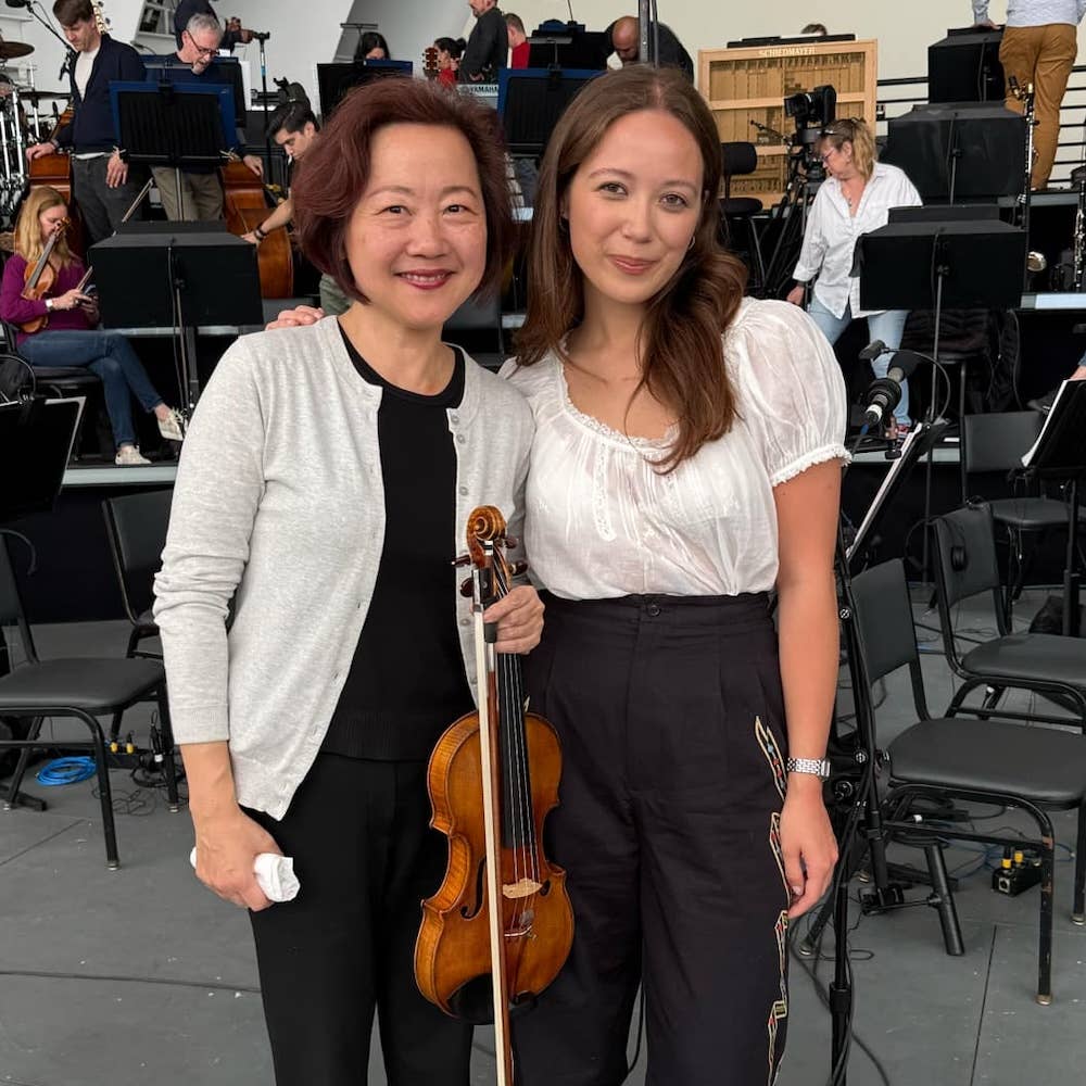 Bing Wang and Laufey pose for a photo together on stage while rehearsing for Coachella.