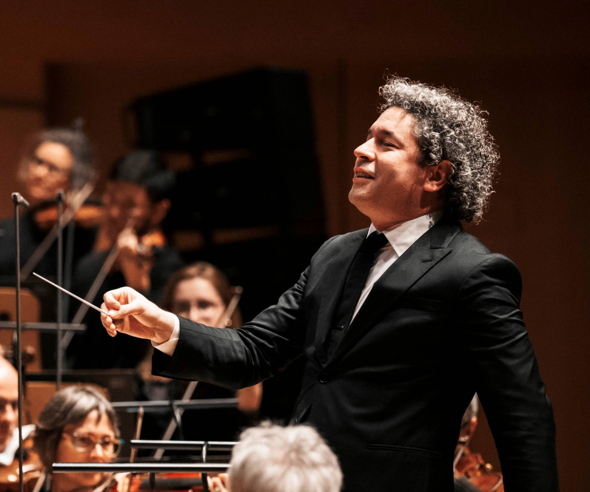 Close up of Gustavo Dudamel conducting and smiling.