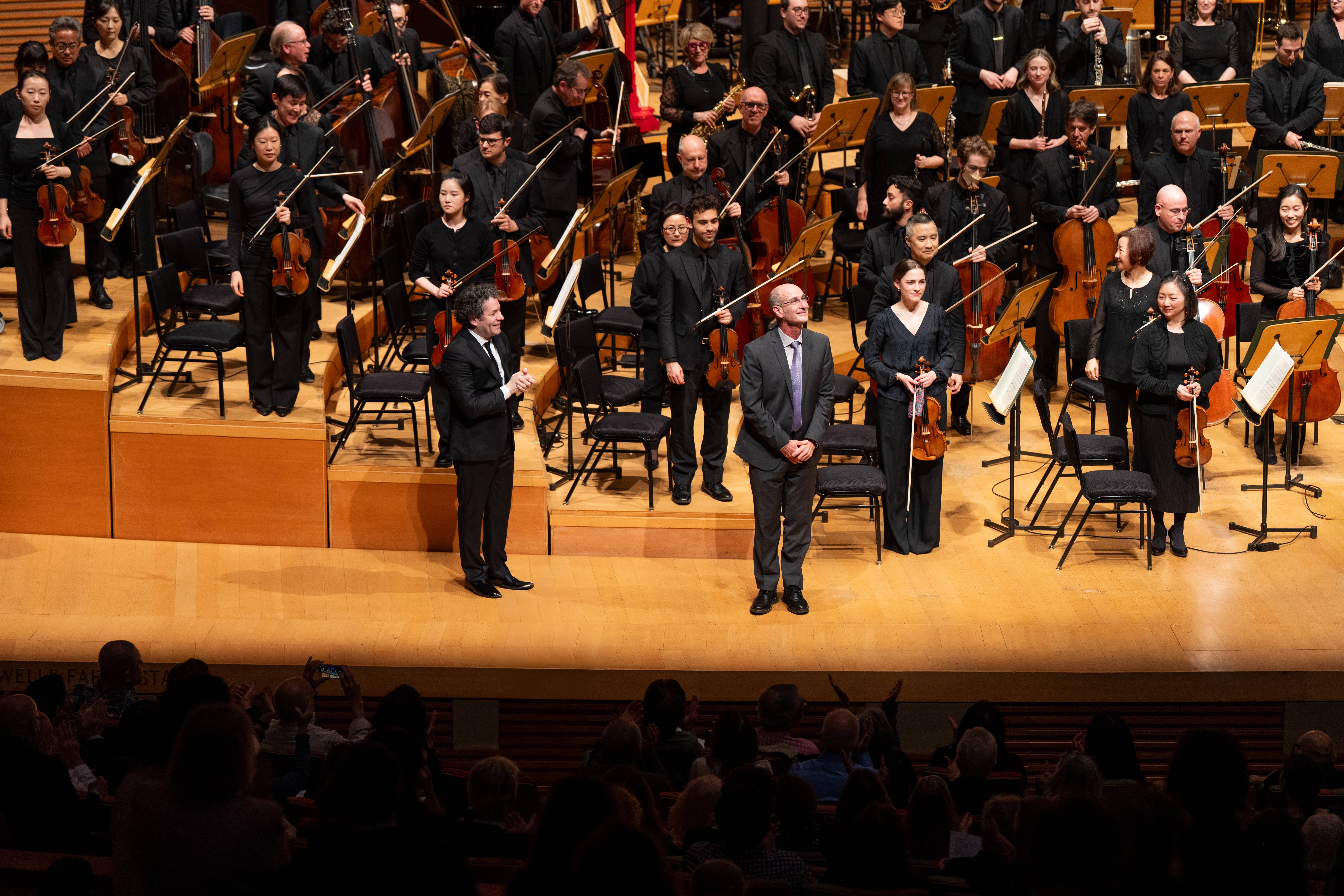 Composer Ricardo Lorenz onstage with Gustavo Dudamel and the orchestra.