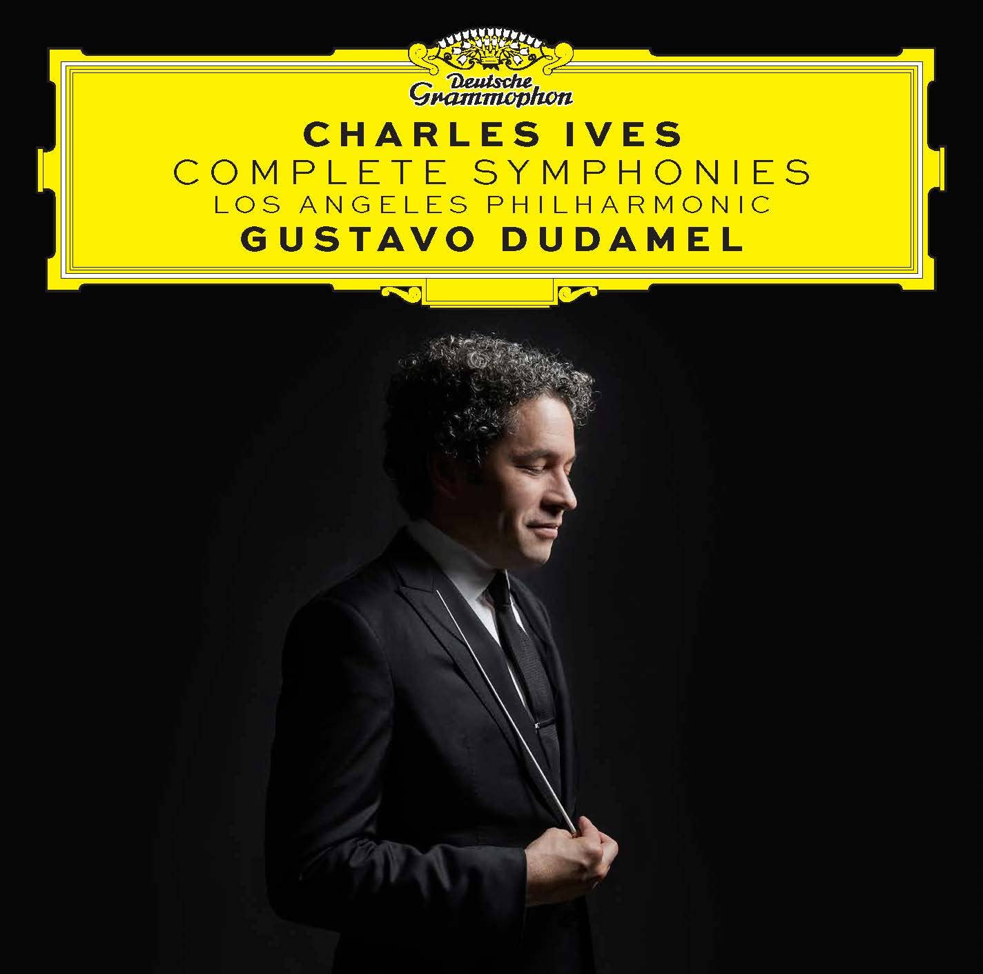 Album cover for Ives: Complete Symphonies recording. Side profile of Gustavo Dudamel against a black background looking down, smiling, holding his baton. Above his head, 